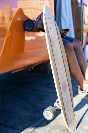 Close up view of an Isolated surfskate skateboard leaning on a vintage van