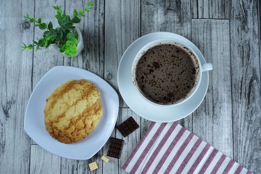 A top view of a pastry and a cup of hot chocolate on the table in a cafe