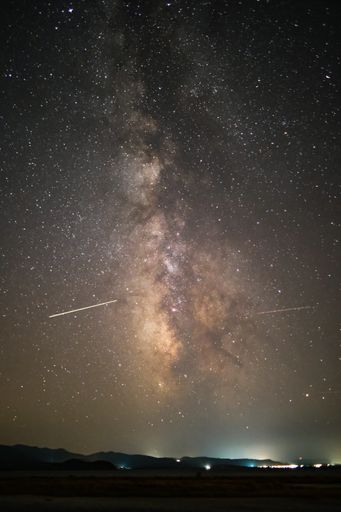 A vertical shot of starred sky with falling stars