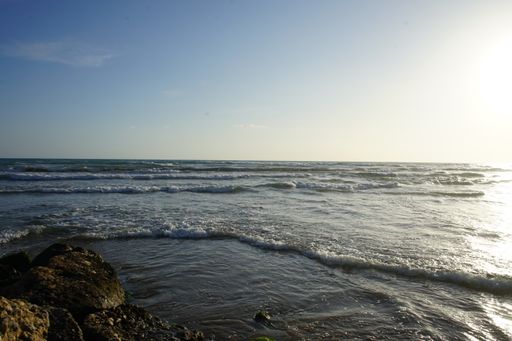 A close-up shot of a beautiful sea with foamy waves rolling and crashing on a rockybeach
