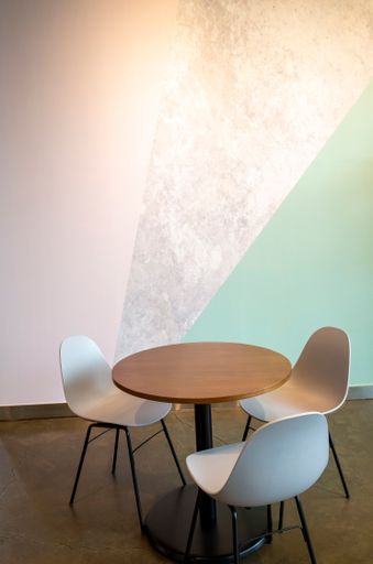 A vertical shot of three chairs around the table in a cafe