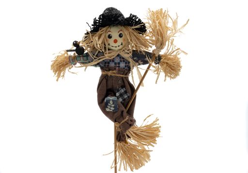 A closeup of a scarecrow with broom isolated on a white background