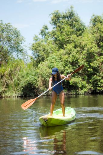 A vertical shot of a Hispanic woman kayaking on a lake