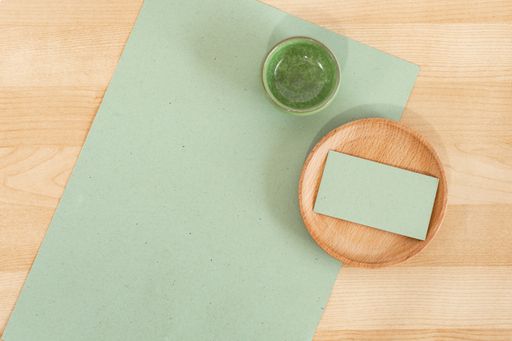 A green rustic carton recycled business visiting card on a wooden desk mockup