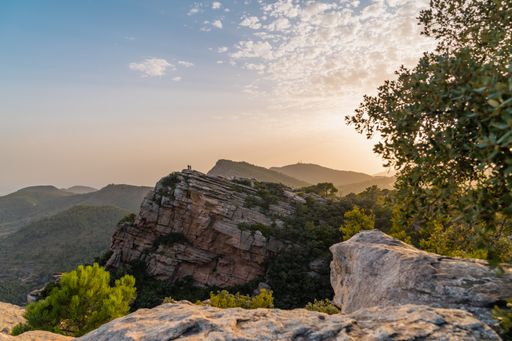 Sunset at the Garbi viewpoint with people in groups in the Sierra Calderona natural park. Valencia, Spain.