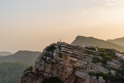 Sunset at the Garbi viewpoint with a woman standing alone located in the Sierra Calderona natural park. Valencia Spain.