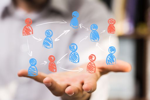A male's hand holding an illustration of the concept of teamwork and partnership