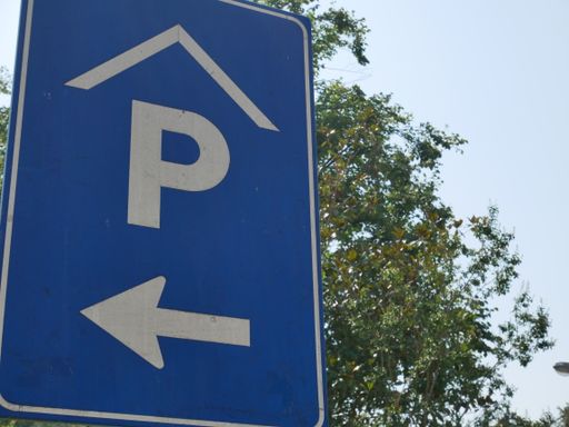 A sign showing a parking lot on the left side