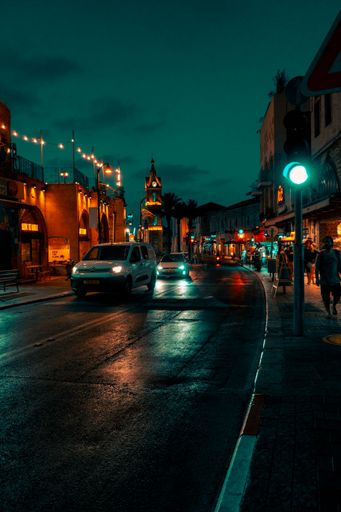 A vertical shot of cars passing along a street in Rosh Pinna, Israel during nighttime
