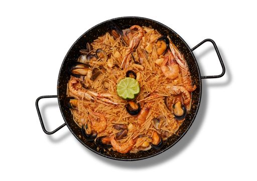 A top view of delicious Fideua with seafood in the pan on the white surface