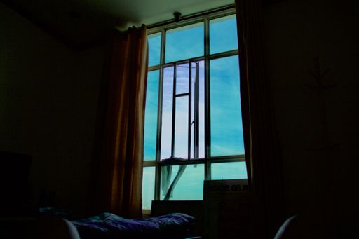 The blue sky from a window of a dark room