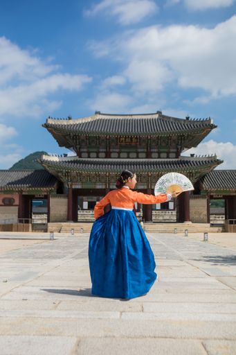 A South Korean young woman in traditional Hanbok dress in Gyeongbokgung Palace, Seoul, South Korea