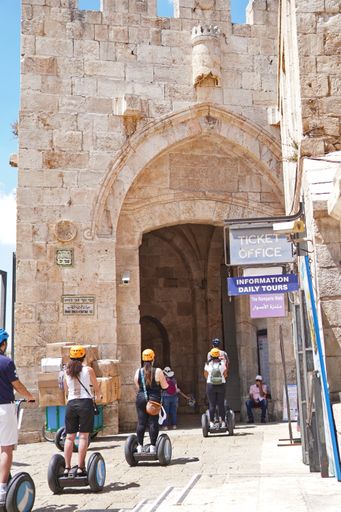 Jaffa gate in Jerusalem, Israel with people riding on Segway vehicles with yellow helmets