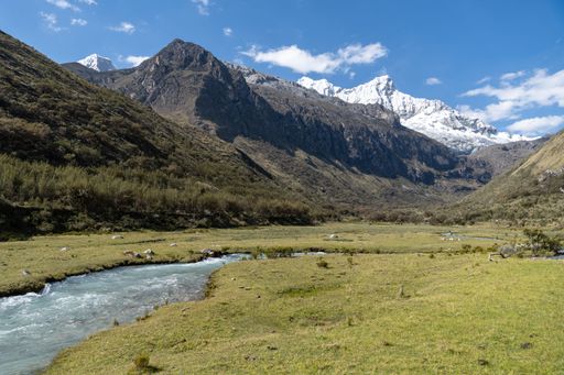 A stunning view of Andes mountains with a river and blue sky in Huascaran National Park, Peru