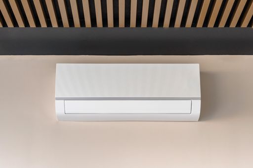 Air conditioner on beige wall room interior background