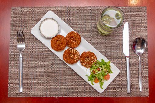 An overhead shot falafel served with salad and tahini dip