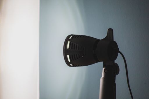 A beautiful shot of a black stage light with a blue wall in the background