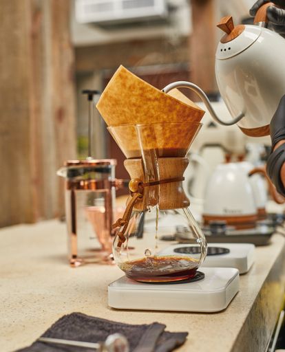 A vertical shot of filtering coffee in a glass decanter