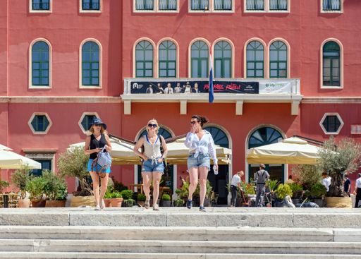 A group of tourists walking through the square in the city of Split in Croatia