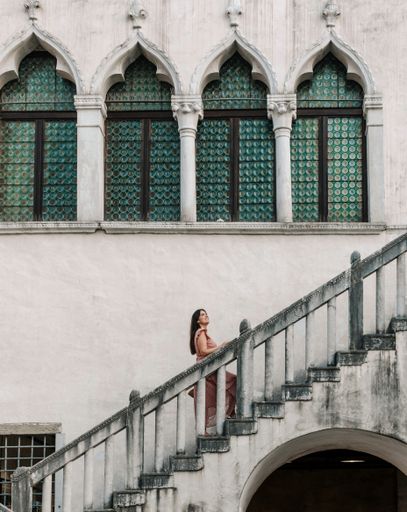 Woman standing on stairs of old building on main square in city of Koper in Slovenia.