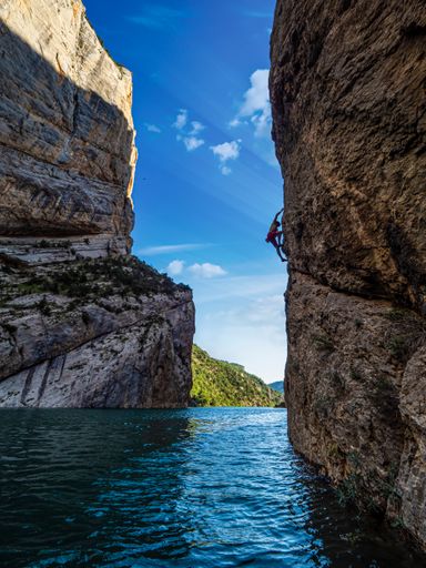 A vertical shot of the man climbing the cliffs.