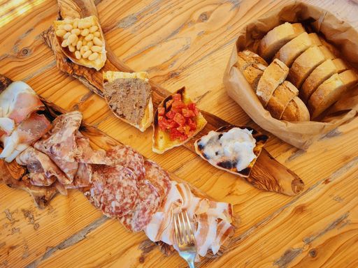 A top view of the platter of Italian cured meats and bruschetta in outdoor farmhouse in Tuscany, Italy