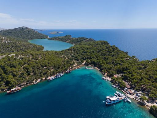 An aerial view of lush greenery and clear blue waters in Telascica Nature Park, Croatia