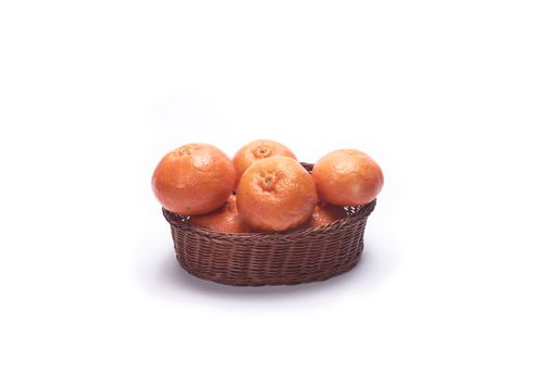 A basket full of tangerines isolated on a white background with free space for text