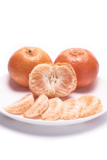 A plate of whole and peeled tangerines isolated on white background with free space for text