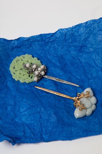 A vertical shot of fancy Korean brooches on a blue paper, South Korea