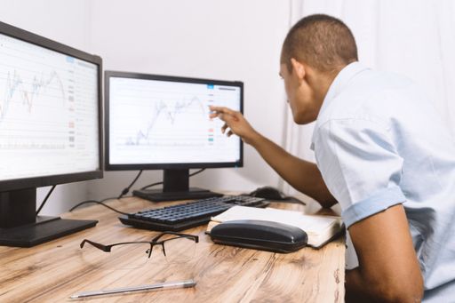 A closeup shot of a young Hispanic man viewing a graph on a computer in the office