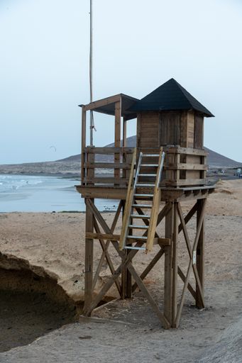 A vertical shot of a life guard watching poll on a deserted beach