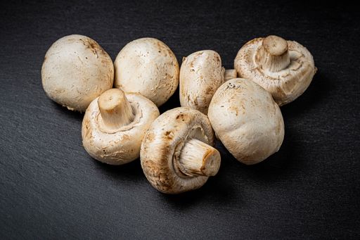 A closeup view of whole champignon mushrooms isolated on a black background