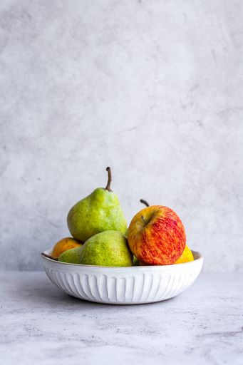 Apples and Pears in Ceramic Bowl on marble background