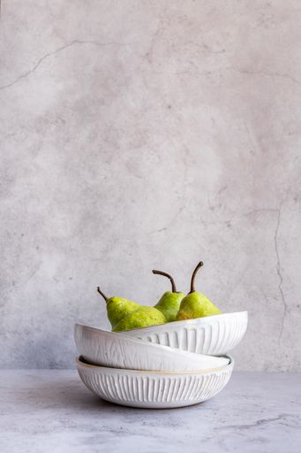 Pears in white Ceramic Bowl on marble background