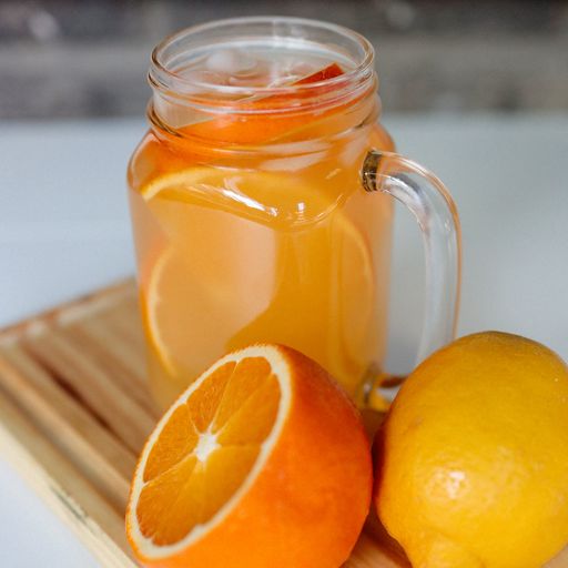 A vertical shot of natural orange juice in a jar with fresh oranges on the board