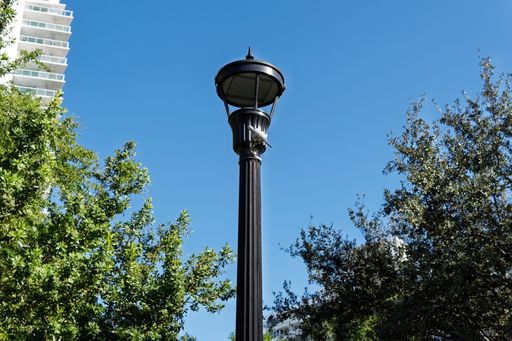 A decorative black lamppost with ornate design against a blue sky
