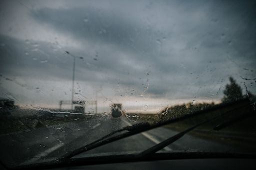 A closeup shot of water drops on the windshield of the car