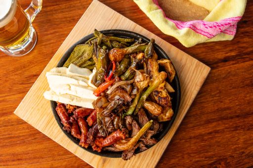 An overhead shot of a traditional Mexican dish with meat and vegetables