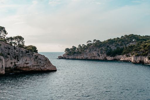 Scenic view of rocky cliffs and calm sea under a partly cloudy sky, perfect for nature and travel themes.