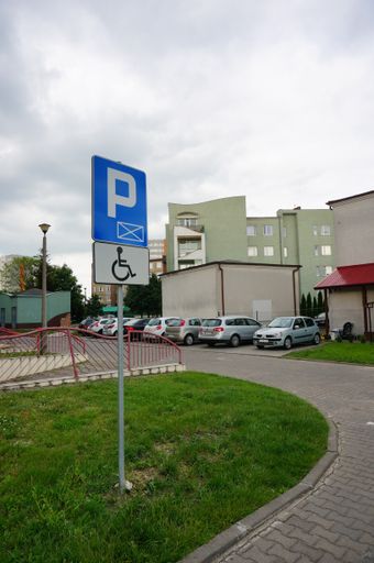 A vertical shot of parked cars close by a parking sign in the Stare Zegrze district, Poland