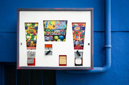 A gumball machine on a blue wall