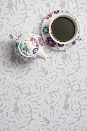 A top view shot of a coffee in a cup and a teapot on a table