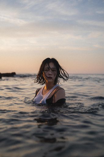 A vertical shot of an attractive South Korean female in the water
