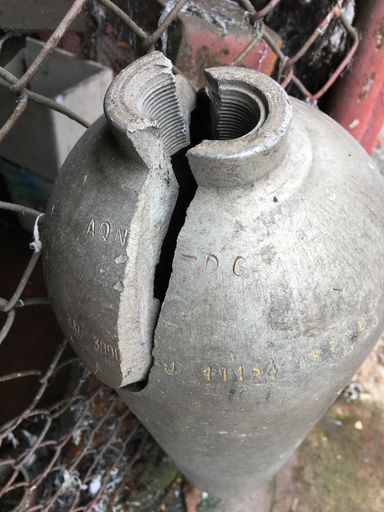A vertical shot of an old ancient antique partly broken jug outdoors