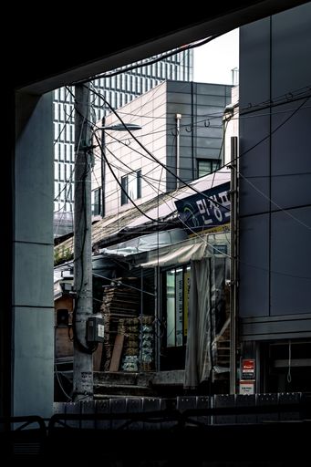 A vertical shot of a messy urban retail store street in Seoul, South Korea through a window