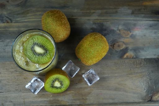 A top view of a kiwi smoothie with ice and kiwis