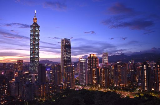 A beautiful shot of lights from the buildings in Taipei, Taiwan with a scenery of sunset and a blue sky in the background