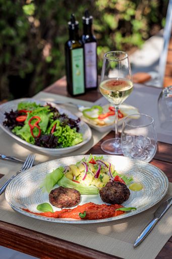 A vertical shot of a glass of wine and delicious dishes in the luxurious restaurant