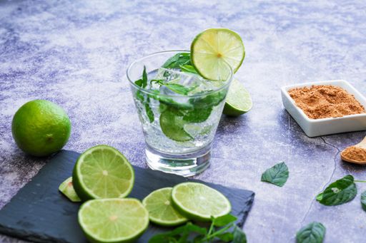 A process of preparing a refreshing drink with lime slices, mint and ice